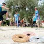 Devant les trophées, des joueurs de pilou se chauffent avant de commencer le championnat.