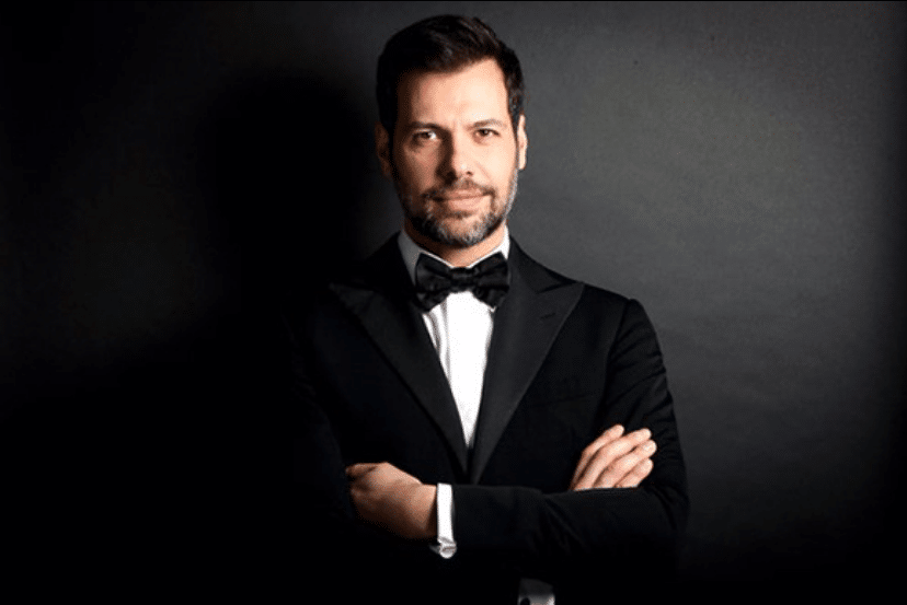 L'acteur français Laurent Lafitte les bras croisé en costume.