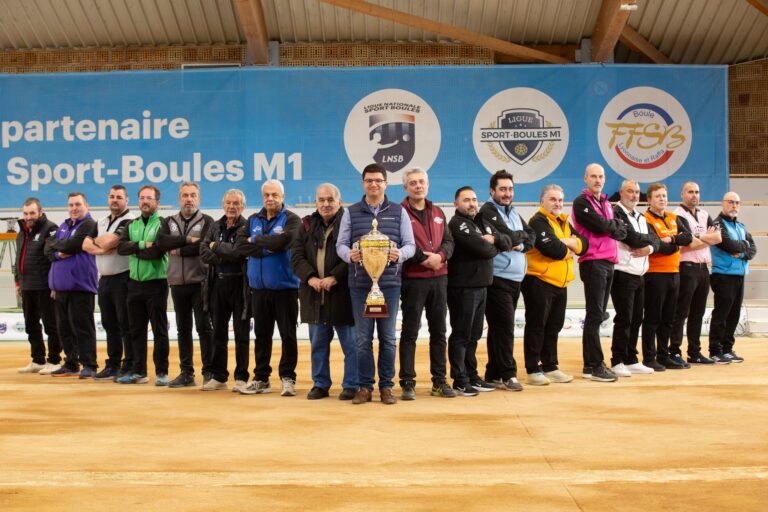 L'équipe de sport boules niçoise avec un trophée dans les mains alignée formant le V de la victoire.