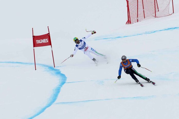 Deux skieurs en compétition handsport. Le second guide le premier.