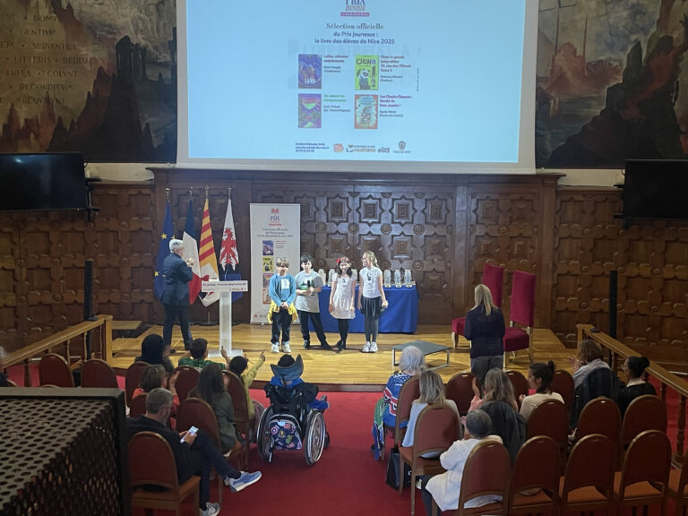 Quatre élèves sur la scène du Centre Universitaire Méditerranéen, interprétant des scènettes en rapport avec les livres lus au cours de l'année scolaire.