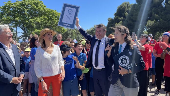 Christian Estosi avec le guinnes woldr record en main. Montrant que le défis été relevé à Nice avec l'aide des enfants.