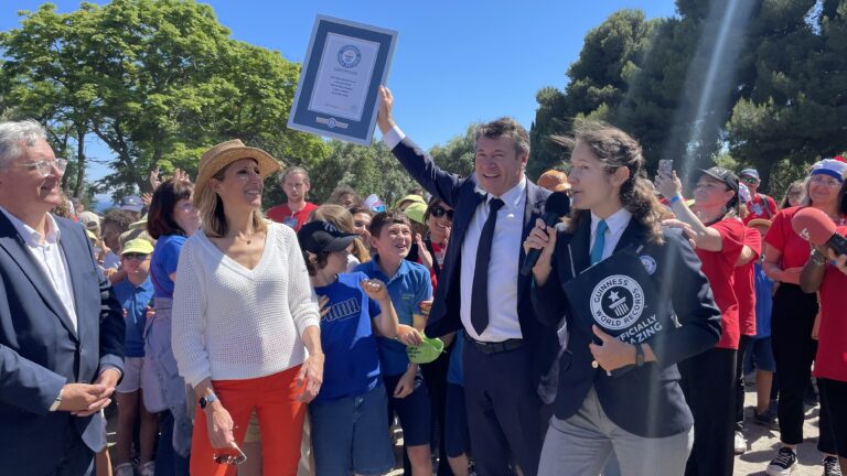 Christian Estosi avec le guinnes woldr record en main. Montrant que le défis été relevé à Nice avec l'aide des enfants.