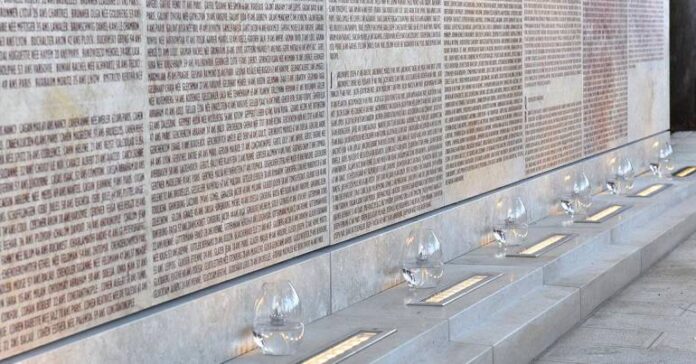 Le mur des déportés de Nice de couleur grise avec des vasques en verre devant.