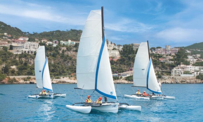 Des jeunes dans des voiliers sur la mer pour l'opération Handi voile.