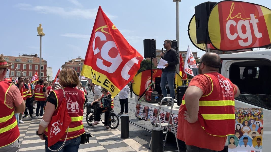 Le camion de la CGT prêt à partir, avec les manifestants autour brandissant leurs drapeaux