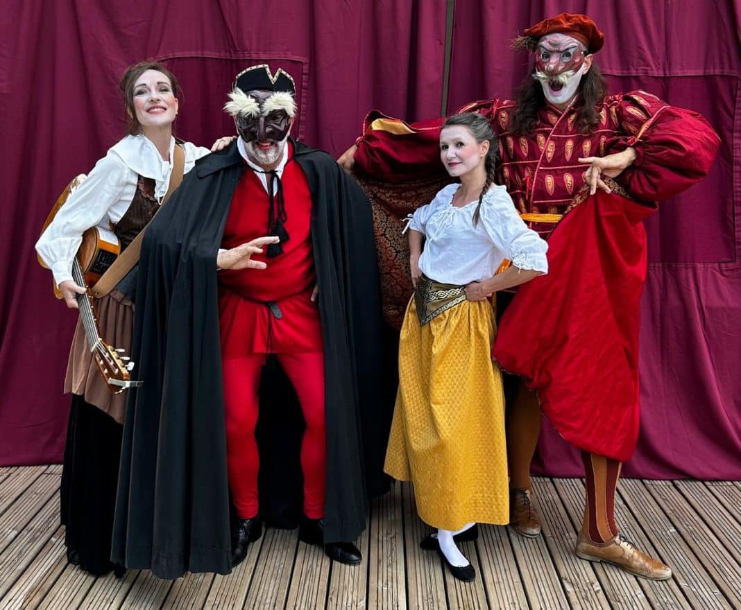 Plusieurs membres du festival Comédia Dell Arte habillé en tenues d'époque très colorées rouge, jaune, noir et blanches