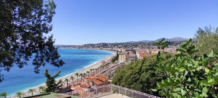 Une vue de la promenade des Anglais à Nice avec la mer et la ville.
