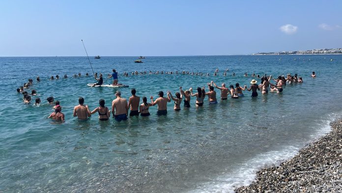 Un groupe d'une cinquantaine de personnes dans la mer pour manifester en faveur de la protection des Océans.