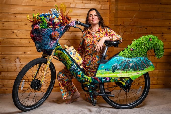 L'artiste Francesca Page prend la pose avec le vélo qu'elle a créé orné de pleins d'éléments rappelant la mer.