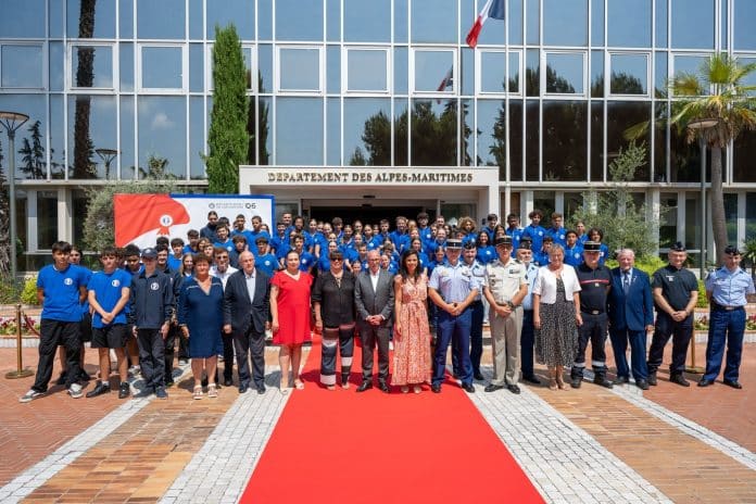 Les collègiens ayant participé au programme des Cadets de la Défense en pantalon noir et tee-shirt bleue au côté des élus.