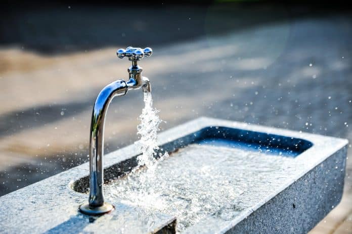 Un robinet d'eau extérieur qui coule.