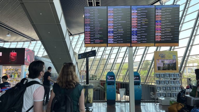 Des passagers scrutant le tableau des vols au départ de Nice