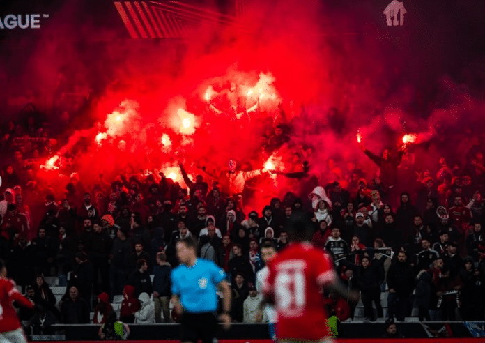 Les supporters du club de Benfica au Portugal font craquer des fumigènes rouges en tribune.