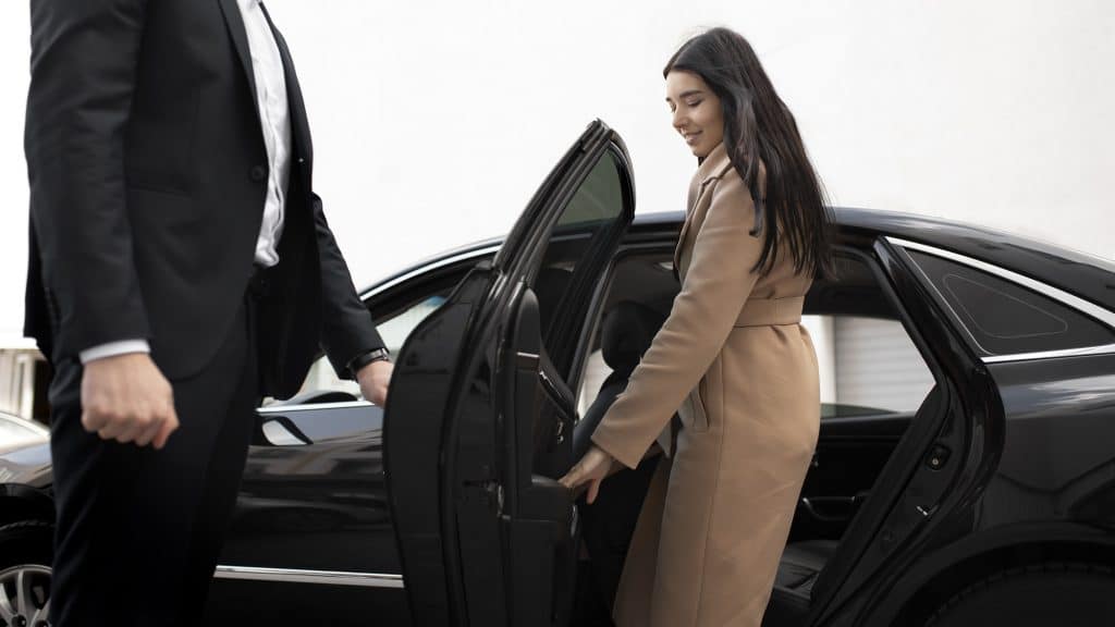 Une femme sort de sa voiture.