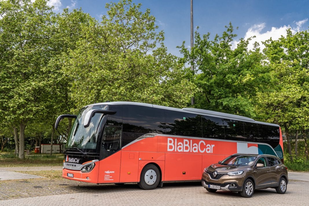 Un bus Blablacar avec une voiture à côté.