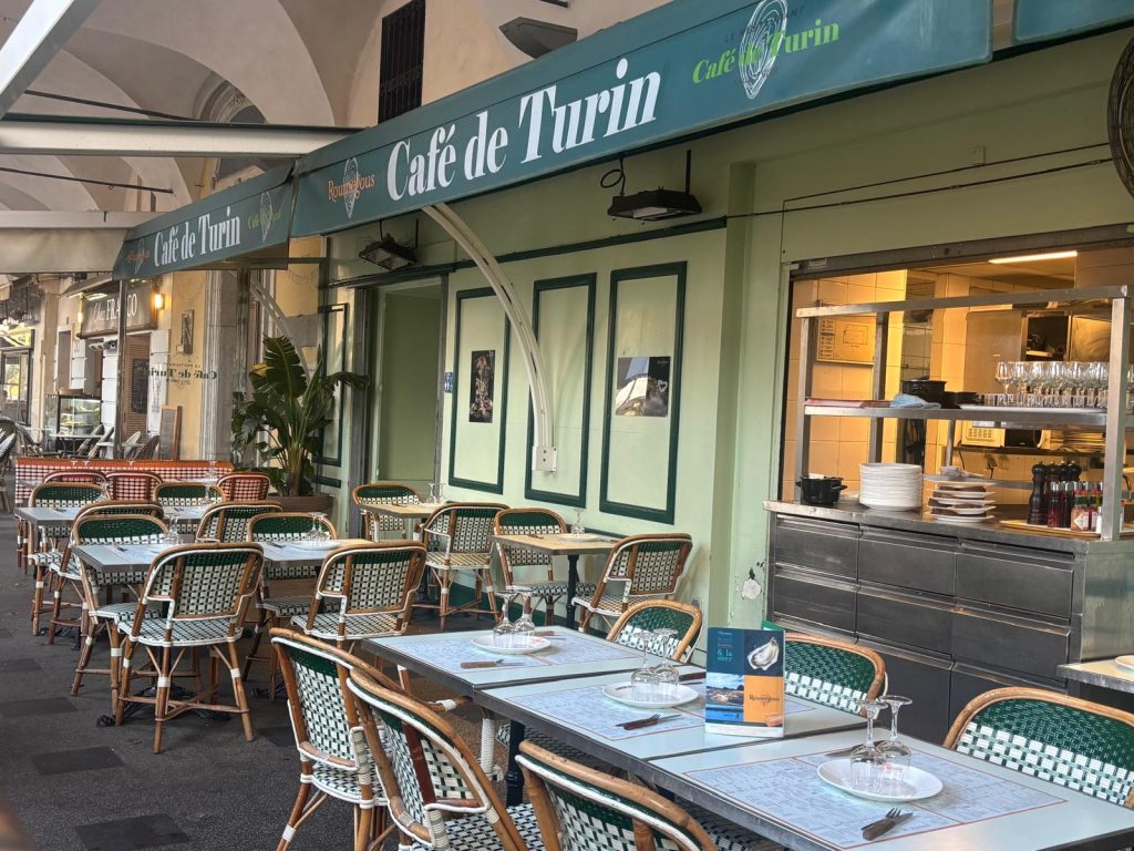 La façade verte et blanche du café de Turin qui trône dans un coin de la place Garibaldi.