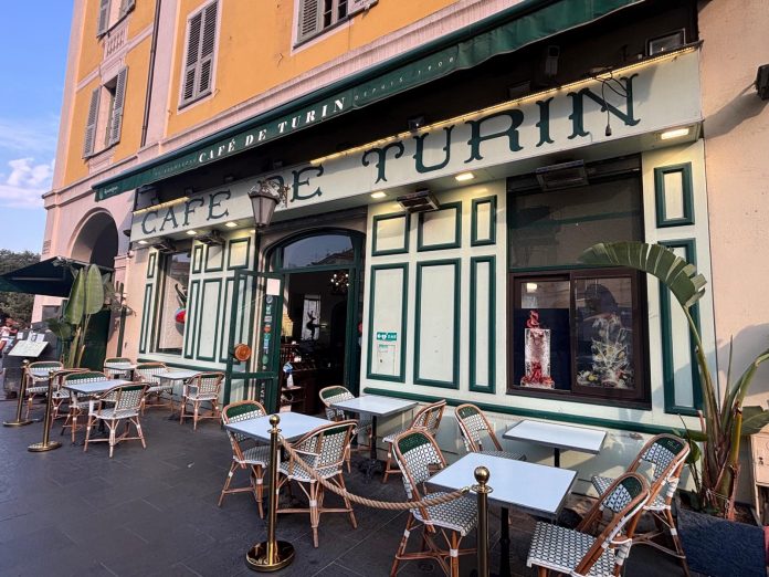 La façade verte et blanche du café de Turin qui trône dans un coin de la place Garibaldi.