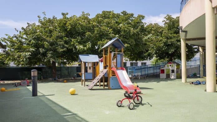 Un extérieur d'une crèche de Nice avec des jeux pour enfant et des arbres en arrière plant.