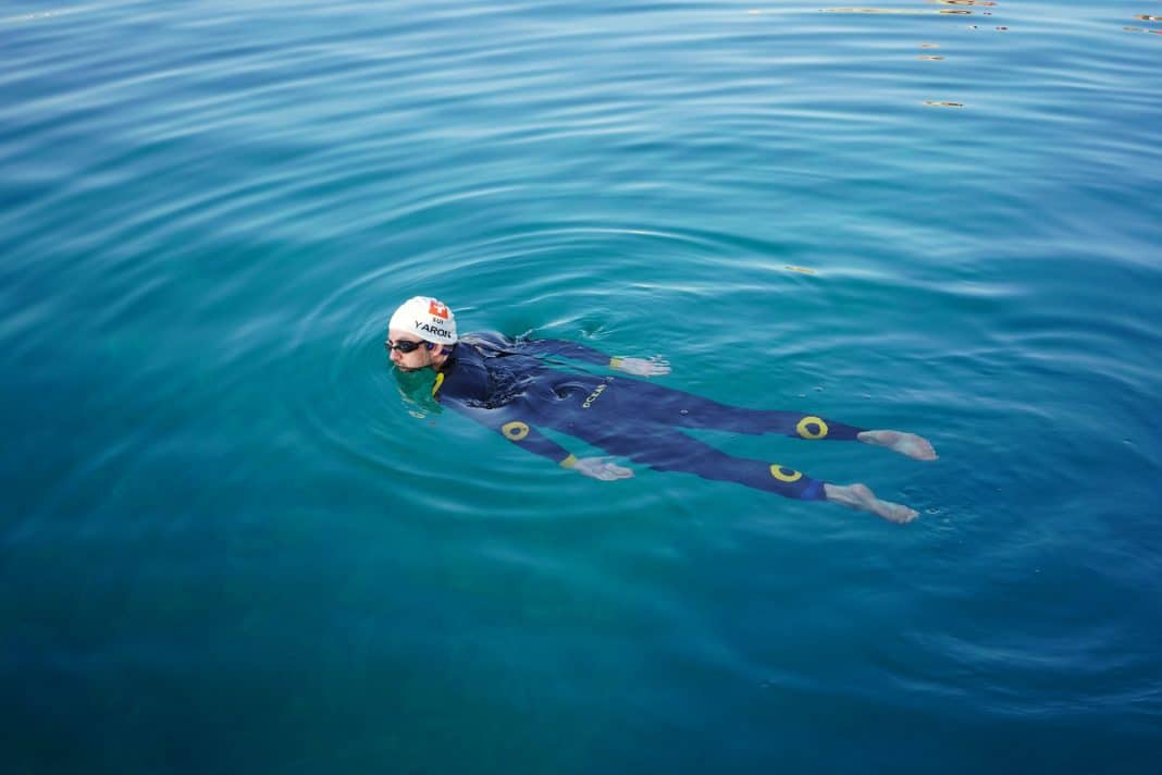 Le nageur Suisse Noam Yaron au départ de sa traversée entre Calvi et Monaco en combinaison intégrale se laisse porter par l'eau turquoise de la Méditerranée.