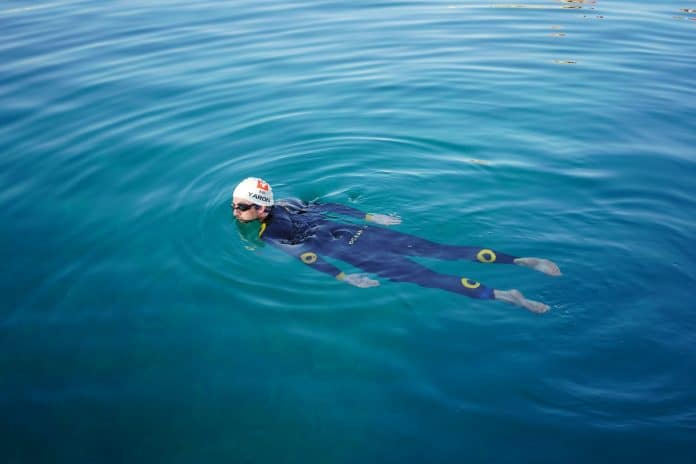 Le nageur Suisse Noam Yaron au départ de sa traversée entre Calvi et Monaco en combinaison intégrale se laisse porter par l'eau turquoise de la Méditerranée.