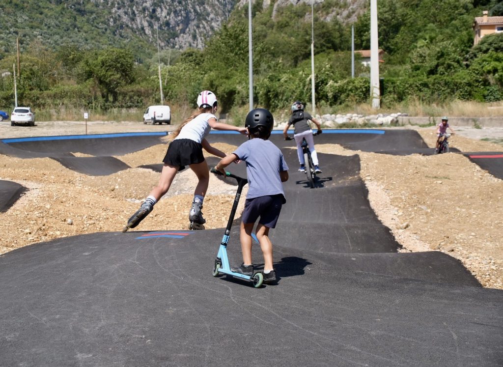 Young people having fun on roller skates, BMX, and scooters on the new Breil-sur-Roya pumptrack.