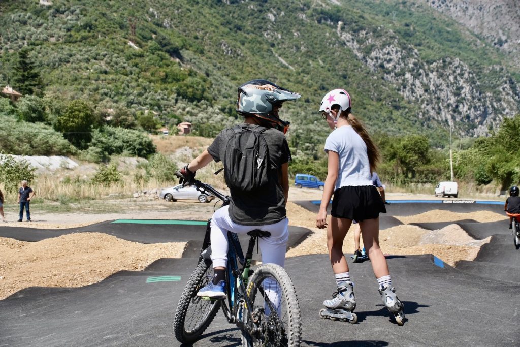Young people having fun on roller skates, BMX, and scooters on the new Breil-sur-Roya pumptrack.