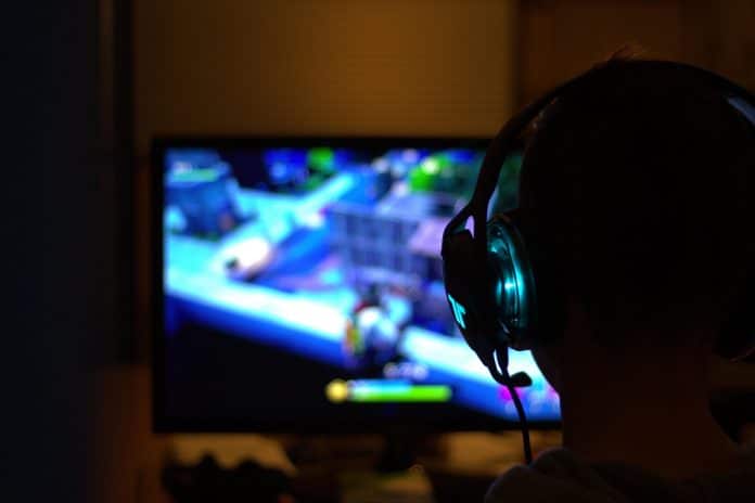 Un joueur de jeux vidéos avec un casque sur les oreilles.