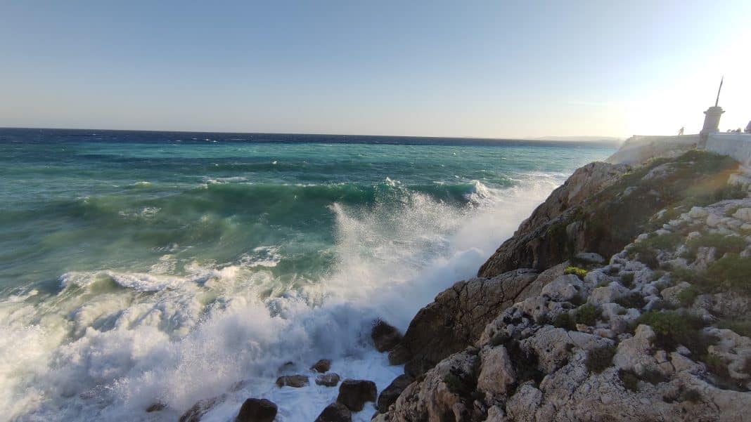 Les vagues frappent les rochers sur la promenade des Anglais.