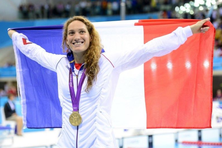 La nageuse Niçoise Camille Muffat avec le drapeau français et sa médaille d'or olympique autour du coup.