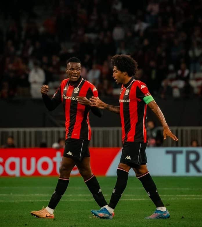 Le capitaine de l'OGC Nice en discussion avec Juma Bah sur la pelouse.