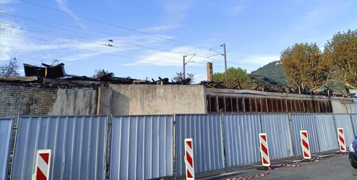 Le bâtiment détruit par les flammes protégé par des barricades.