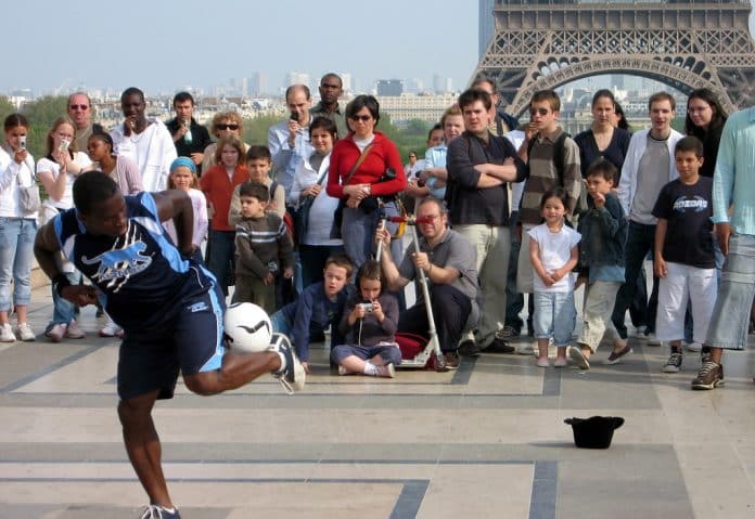 Photo d'illustration. Le freestyler Iya Traore en pleine performance face à une foule devant la Tour Eiffel, à Paris