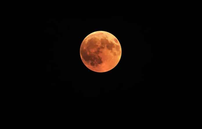 La pleine lune d'une couleur rouge ocre à l'occasion d'une éclipse de lune.