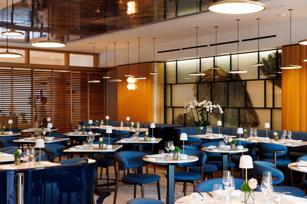 L'intérieur du restaurant Nakamoto très design avec des chaises bleu dans une ambiance lumineuse.
