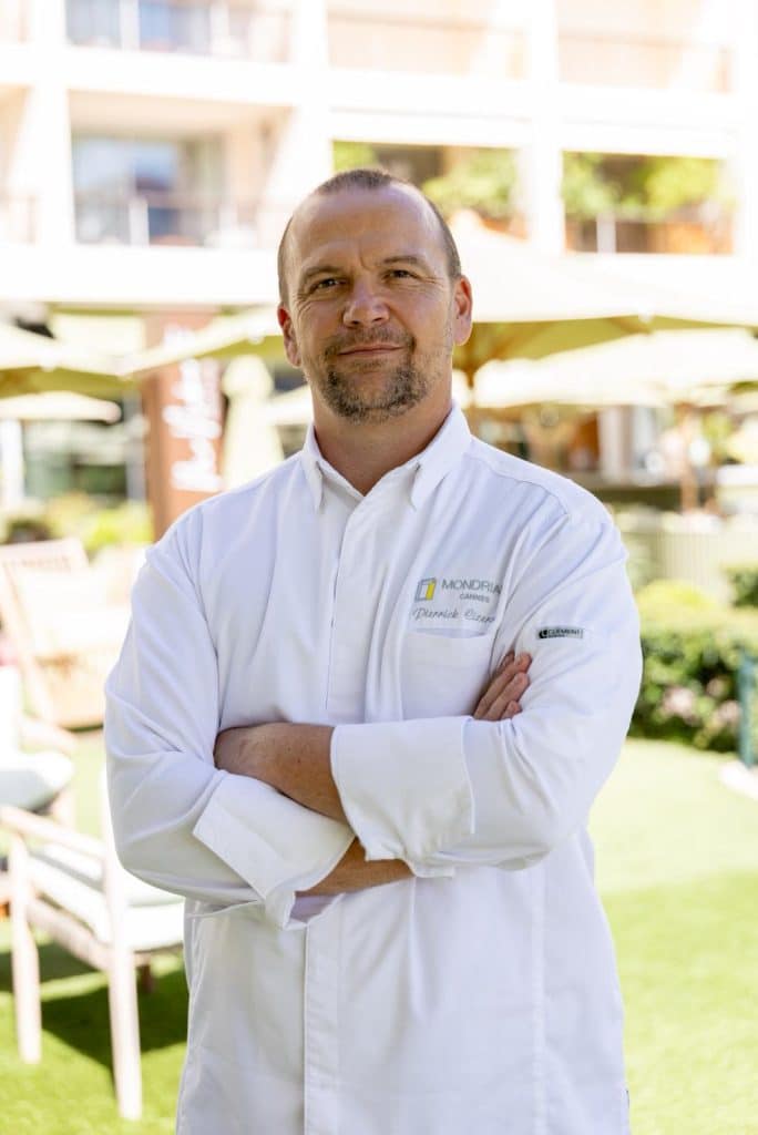 Le chef du restaurant les bras croisés en tenue.