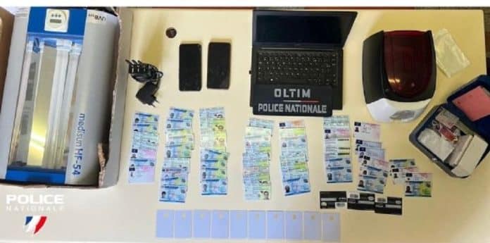 Des fausses cartes d'identités et une machines.