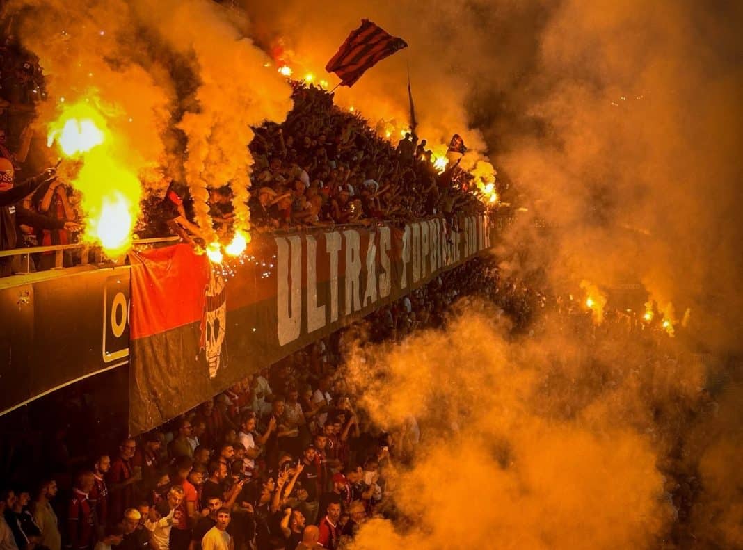 les supporters des la populaire sud de l'OGC Nice dans un nuage de fumigène orange.