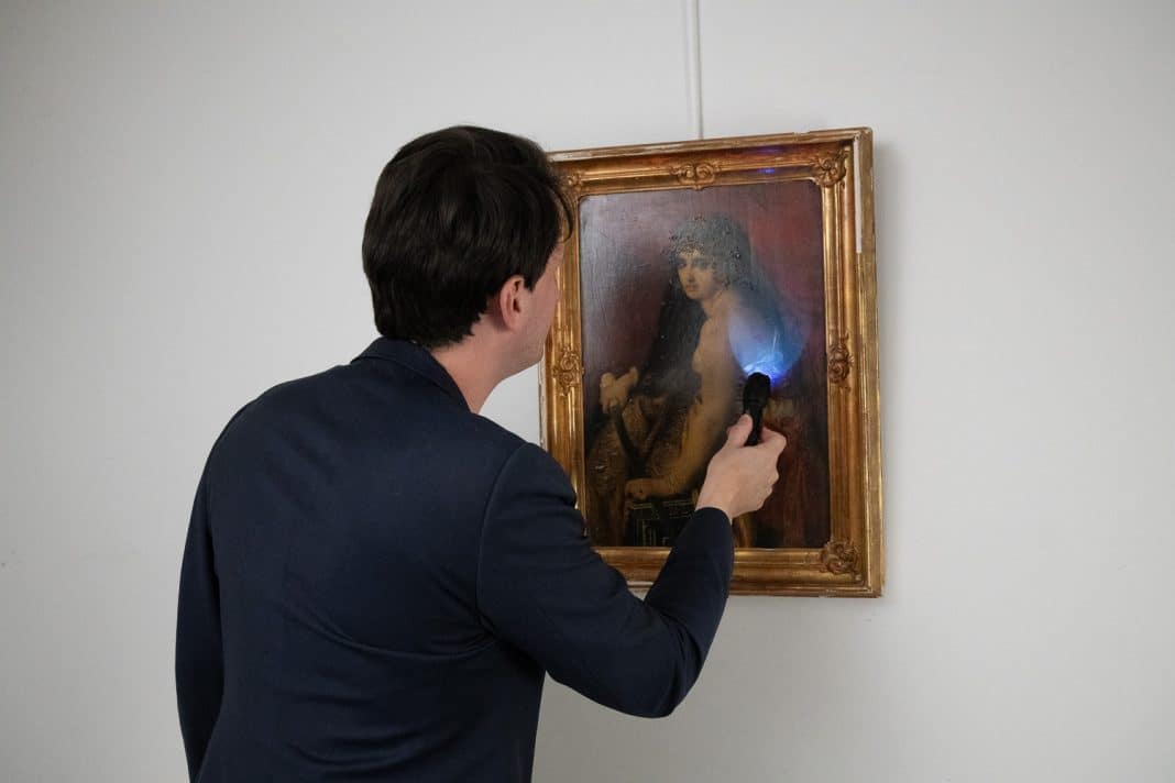 Illustration, Quentin Charraudeau, président de NEO Enchères, expertisant un tableau, de dos