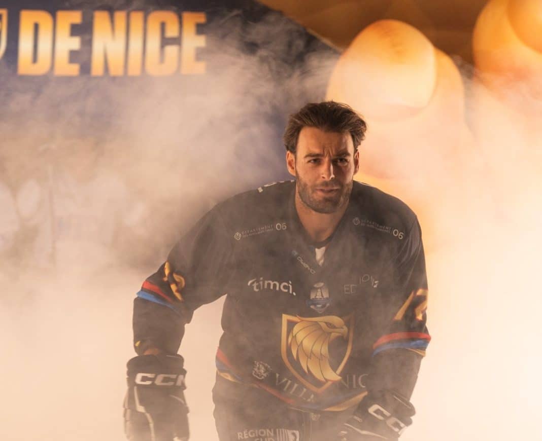 Un hockeyeur des Aigles de Nice entre sur la glace avec es effets spéciaux derrière lui et de la fumée.