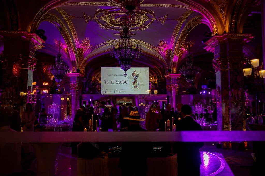 The room plunged into darkness with purple lights and the screen showing the amount raised during the evening.
