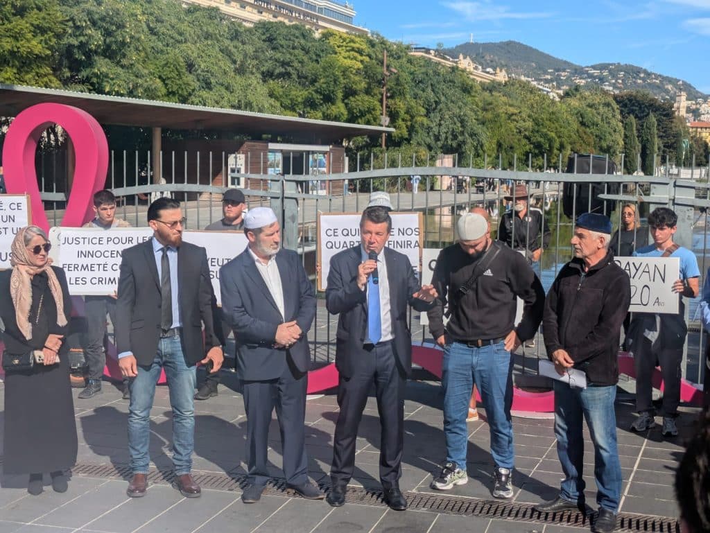 Christian Estrosi prenant la parole lors de l'appel au rassemblement du 8 octobre place Masséna pour rendre hommage aux victimes de la fusillade du 3 octobre dans le quartier des Moulins à Nice. À sa droite, l'imam et président de l'association des Tchéchènes et Ingouches des Alpes-Maritimes, Magamadov Ramzan, à sa gauche,le fils d'Oysghur Tapashev, tué dans la fusillade.
