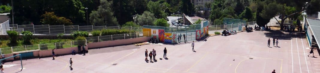 La cours du collège Jean Henri Fabre de Nice avec des enfants et un cadre arboré.