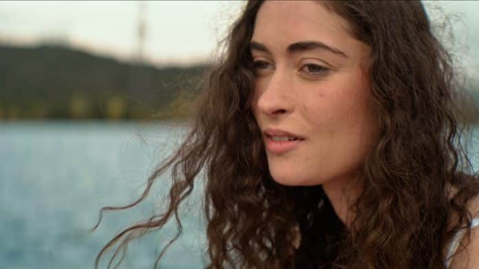 L'actrice niçoise Lou Amara au bord de la mer avec ses longs cheveux long dans le vent.