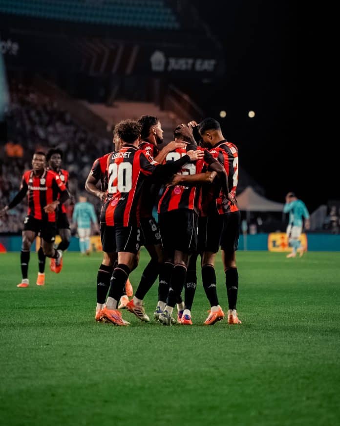 Les joueurs de l'OGC Nice en rouge et noir se félicitent après avoir marqué un but.
