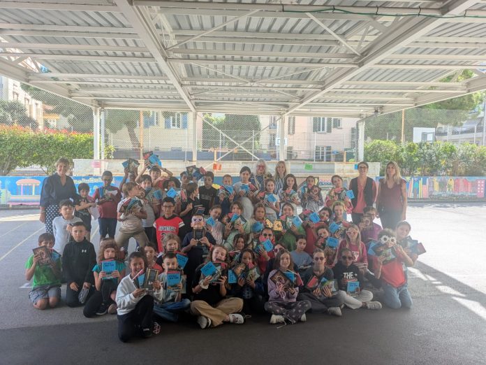 Susie Morgenstern et les élèves de CM1-CM2 de l'école Von Derwies de Nice participant aux prix Jeunesse - le livre des élèves de Nice 2025, tenant dans leurs mains les 4 livres sélectionner pour le concours.