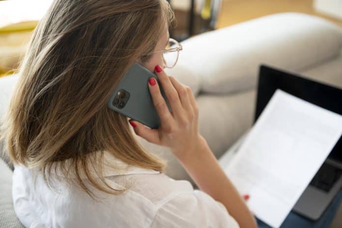 Une femme de dos au téléphone avec son portable.