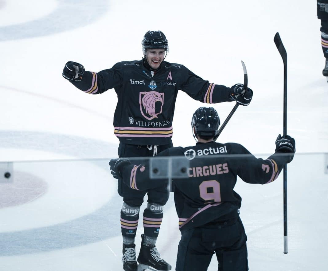 Les Aigles de Nice heureux sur la glace après avoir marqué dans leur tenue bleue foncée cross en l'air.