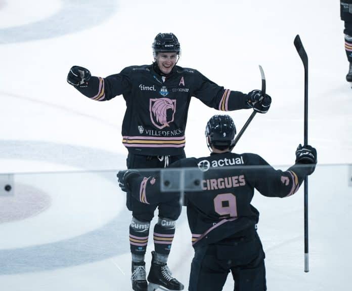 Les Aigles de Nice heureux sur la glace après avoir marqué dans leur tenue bleue foncée cross en l'air.