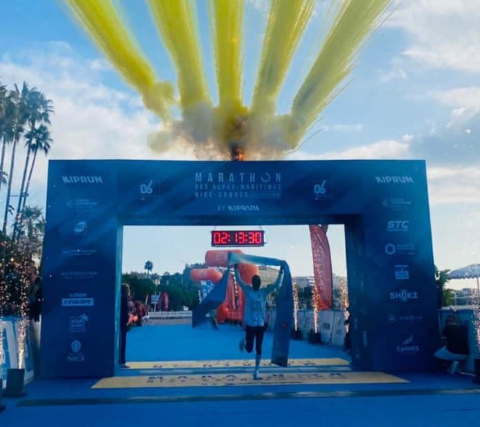 Dickson Kiprop La marathonien Kényan Dickson Kiprop vainqueur de la 17e édiion du marathon Nice-Cannes avec des artifices jaunes au dessus de lui lorsqu'il franchit la ligne d'arrivée en levant les bras.